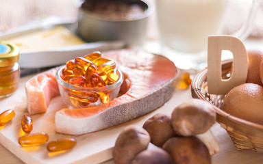 Natural source of vitamin D in Salmon, eggs, mushroom, fortified milk, margarine, canned tuna and fish oil capsule on wooden texture and background, healthcare and supplemental concept