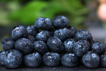 Fresh wet blueberry heap on green background.