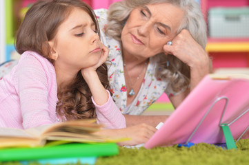 Obraz premium girl and grandmother doing homework