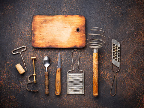 Old vintage kitchen utensils on rusty background