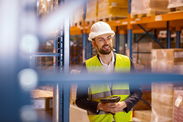 Storehouse worker. Delighted nice man using a scanner while working in the storehouse
