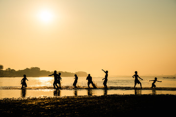 Fototapeta na wymiar Silhouette of children playing water with friend
