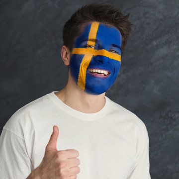 Young man with Sweden flag painted on his face