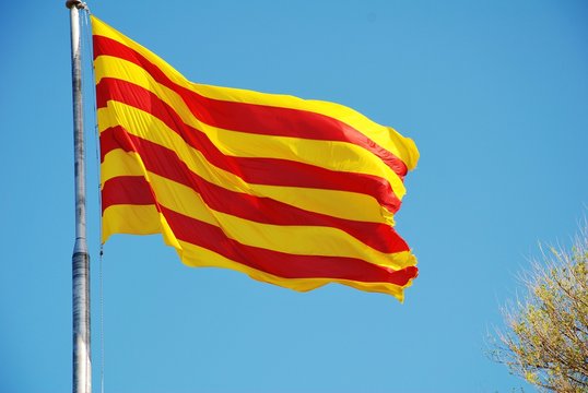 La Senyera, the red and yellow flag of Catalonia flying in Barcelona, Spain.