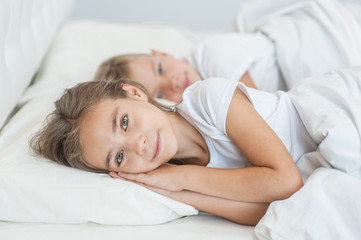 Obraz na płótnie Canvas Happy girl with brother lying on bed