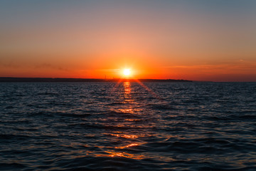 The light of the sunset, shining on the waves of the sea.