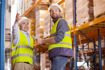 Pleasant collaboration. Delighted positive men smiling while enjoying working together