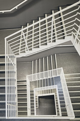 Looking down at a modern staircase with white wall as to be found in an office, hospital or an apartment.