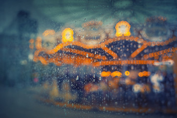 Rainy carousel through wet glass / window. Moody / retro styled and colored bacground photo