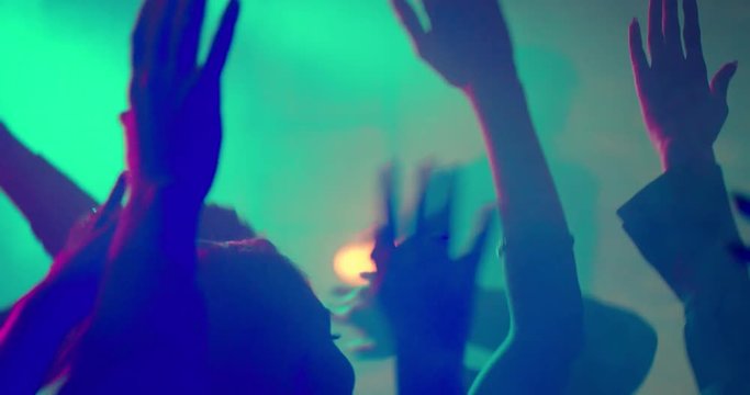 Hands at a Party in Slow Motion/Put your hands in the air! Friends having fun at a party or concert, a festival. They hold hands above their heads, cheering the performer. Slow motion shot