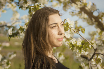 Girl with flowers background looking out of the camera
