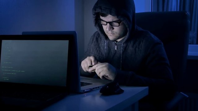 4k footage of hacker working on laptopn stealing money from credit card