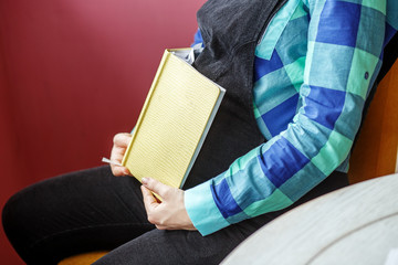 Obraz premium Pregnant woman with a book. Waiting for childbirth. Concept of life style, motherhood, reading, family.