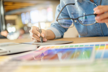 Graphic design and color swatches and pens on a desk. Architectural drawing with work tools and...