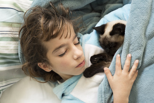 10 Year Old Girl Sleeping In Bed With Her Cat On Top.