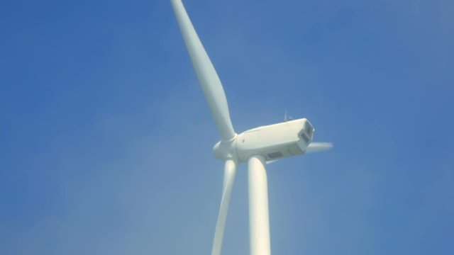 風力発電の風車にかかる霧が晴れる