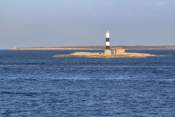 Lighthouse in the sea - obrazy, fototapety, plakaty