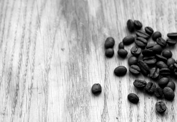 Coffee beans on wooden board with blur effect in black and white.