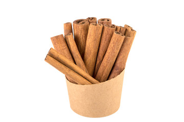 a lot of cinnamon sticks in a paper cup on a white background