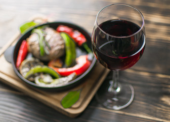 A glass of wine on a background of eating on a dark wooden background.