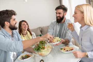 Obraz na płótnie Canvas Positive happy young people enjoying food at home