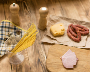 Fototapeta na wymiar Ingredients for Italian pasta. Raw spaghetti, ham, spices.