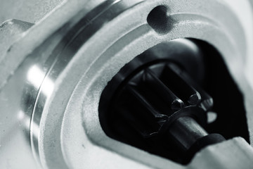 Background image of auto parts with rotor close-up. Big black pinion in metal part. Gear parts...