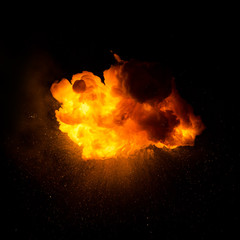 Realistic fiery explosion with sparks over a black background