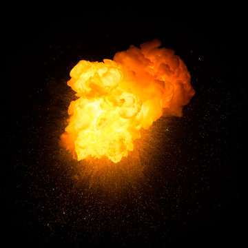 Realistic fiery explosion with sparks over a black background