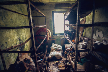 Fototapeta na wymiar Ruined old forgotten room with mess and shelves in disorder in the abandoned deserted house.