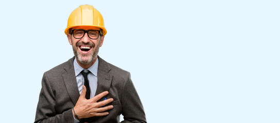 Senior architect or engineer confident and happy with a big natural smile laughing isolated over blue background