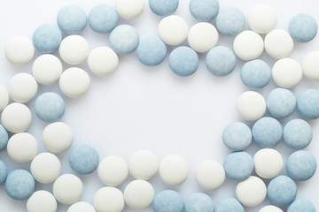 White and blue pills on light surface