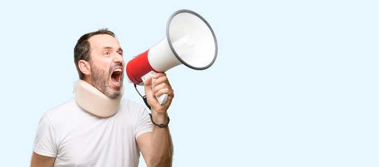 Injured senior man using a neck brace communicates shouting loud holding a megaphone, expressing success and positive concept, idea for marketing or sales isolated over blue background