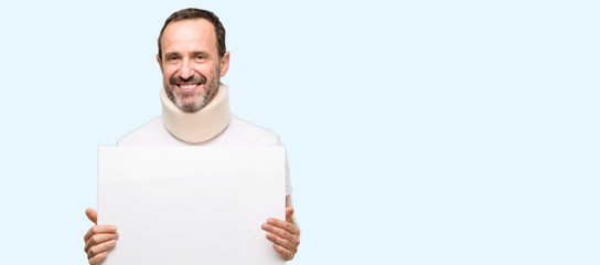 Injured senior man using a neck brace holding blank advertising banner, good poster for ad, offer...