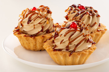 Cake with cream and caramel polished laid out on a white plate