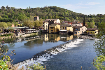 Fototapeta na wymiar Il paesino di Borghetto sul Mincio,si rispecchia tranquillo nelle calme acque del fiume.