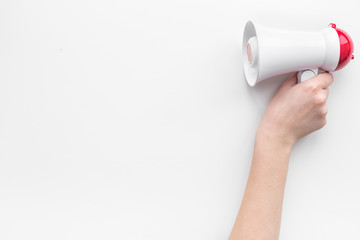 Attract attention concept. Megaphone in hand on white background top view copy space
