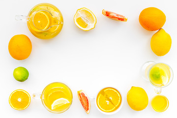 Fruit tea. Teacup and teapot among citrus on white background top view copy space