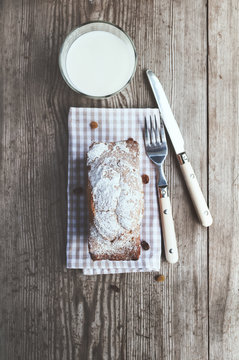 Freshly baked cake and a glass of milk on the wooden table. Rustic style