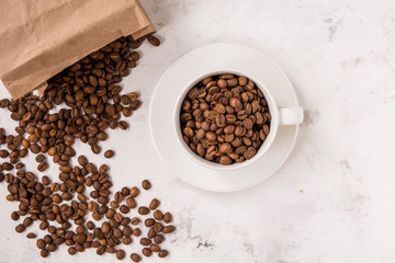 Coffee beans in a cup on a white table