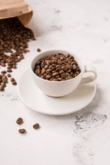 Coffee beans in a cup on a white table
