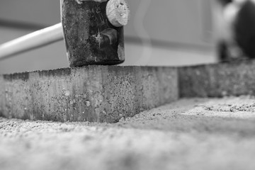 Greyscale image of new paving stones being installed outdoors
