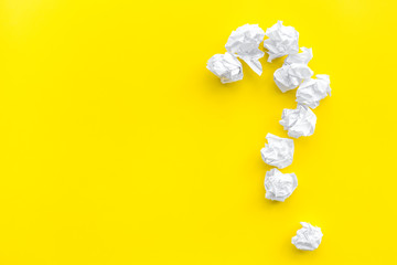 Question mark lined with crumpled paper on yellow background top view copy space
