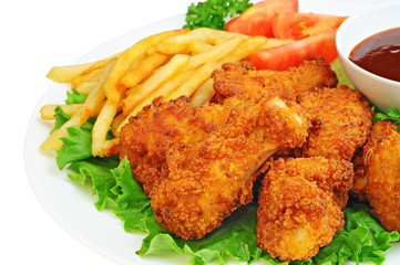 Chicken wings and drumsticks with french fries, barbecue sauce and vegetables