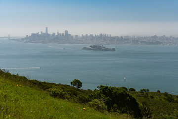 Wide sweeping view of the Golden Gate Bridge, city of San Francisco, and surrounding bay seen from up high on Angel Island