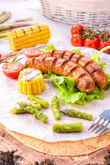 grilled krakauer sausage with boiled corn and green salad