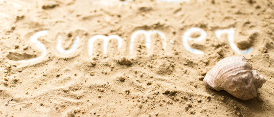 Fototapeta na wymiar Summer inscription on a sandy background. The concept of travel