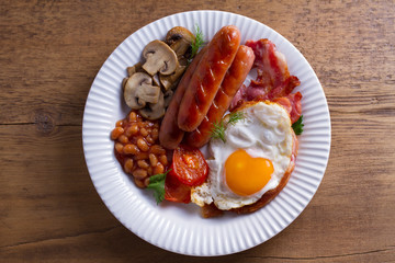 Full English or Irish breakfast: sausages, bacon, egg, mushrooms, tomatoes and beans. Nutritious morning meal