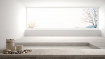 Wooden vintage table top or shelf with candles and pebbles, zen mood, over blurred empty room with...