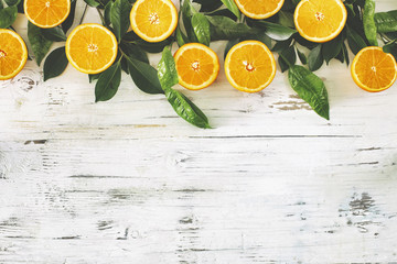 Half cut orange fruit and leaf on the vintage wooden background